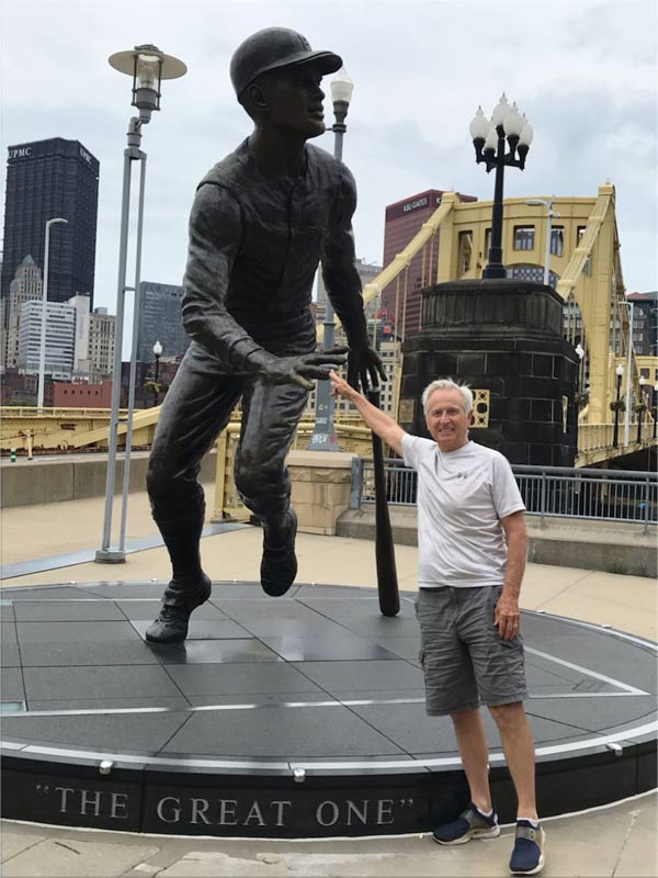 JP touching the hand of the statue of Roberto Clemente outside the baseball field in Pittsburg