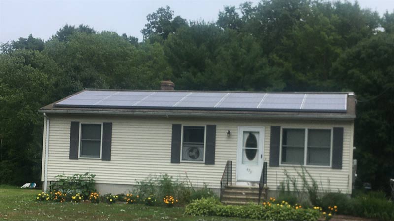 A photovoltaic solar system covers the entire roof of a modest home.
