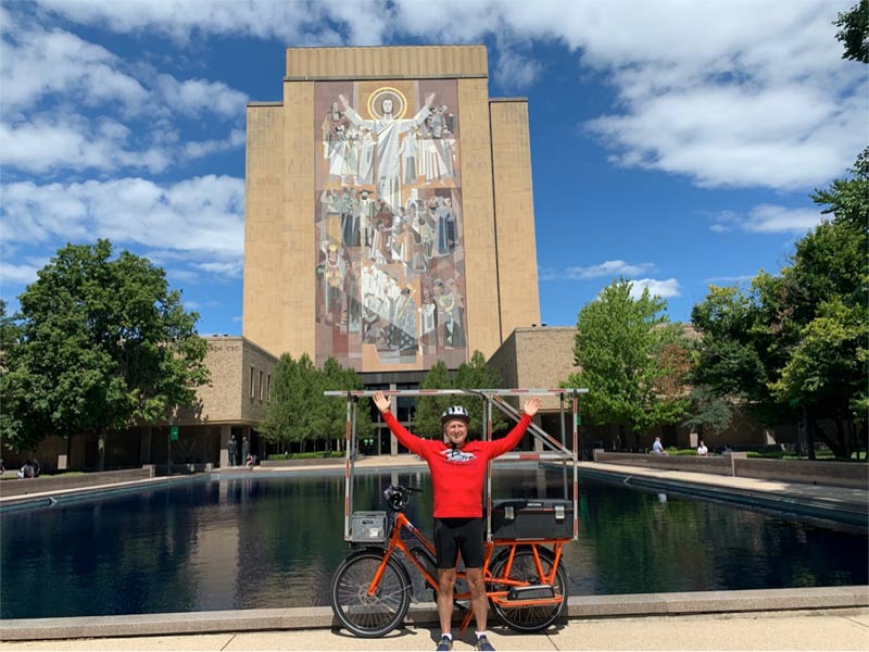 John and Sunride in front of Notre Dame University reflecting pool and mural of Christ on the Hesburgh Library, commonly known as "Touchdown Jesus."