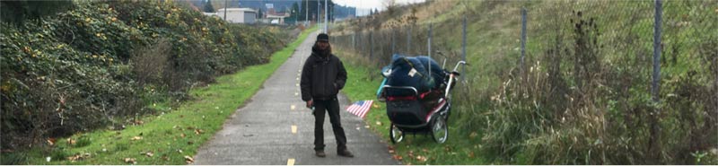 Homeless man with an American flag on the buggy holding all his belongings